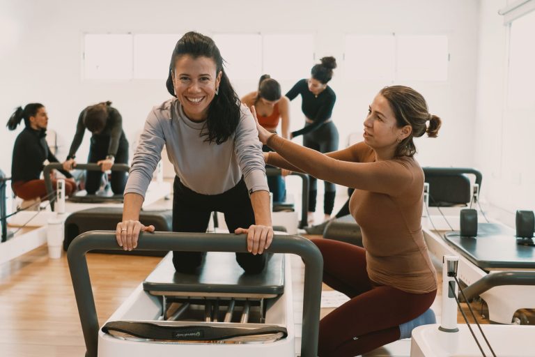 Profesora de NEPO corrigiendo a una alumna en el Reformer